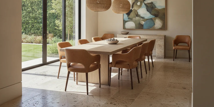 A refined dining room with leather-upholstered chairs around a warm wood table